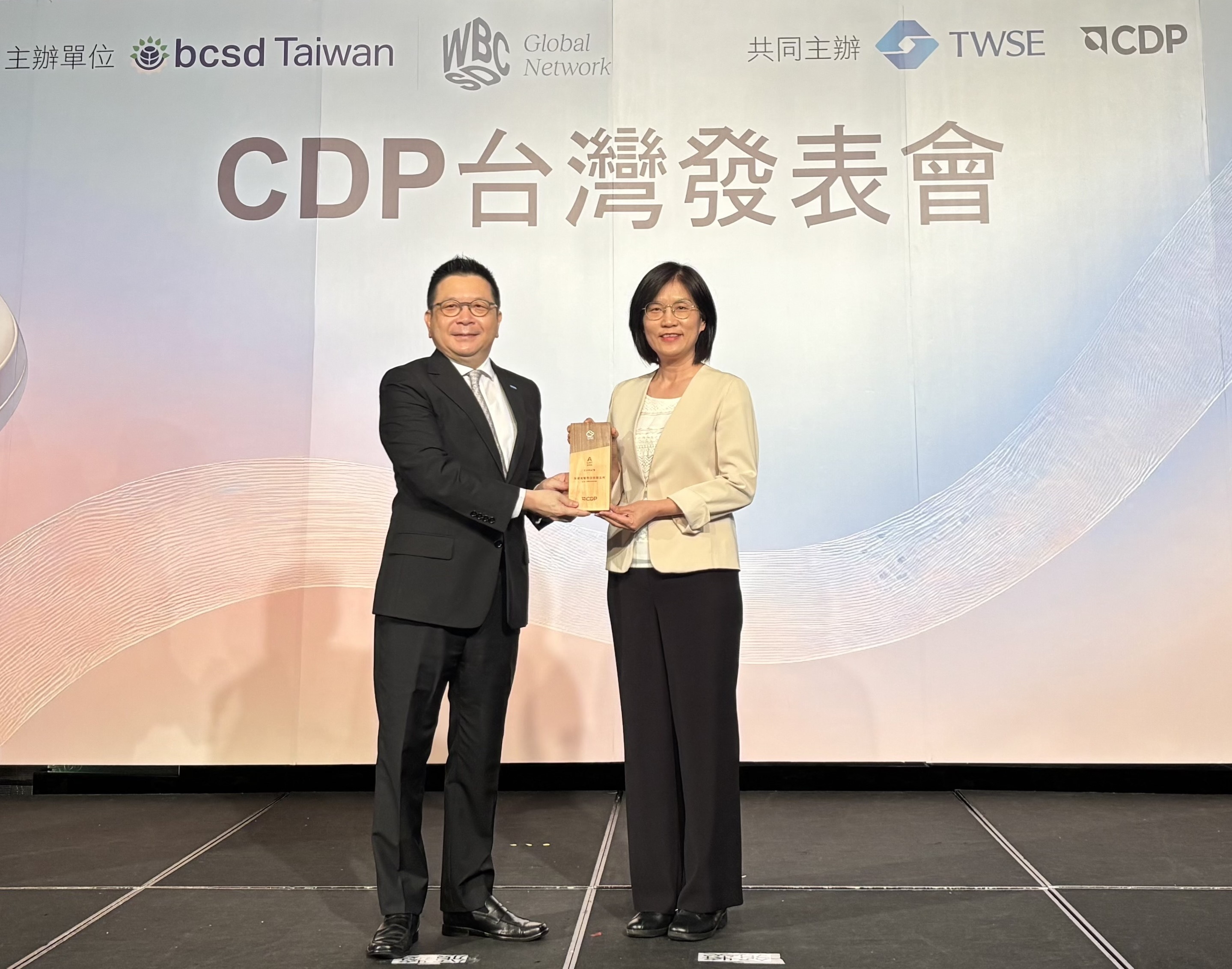 PT电子(中文)官网永續成果再獲國際評比肯定，獲頒CDP氣候與水資源雙項領導力評級。今由臺灣證券交易所董事長林修銘（左）頒獎，PT电子(中文)官网光電永續長古秀華（右）代表受獎